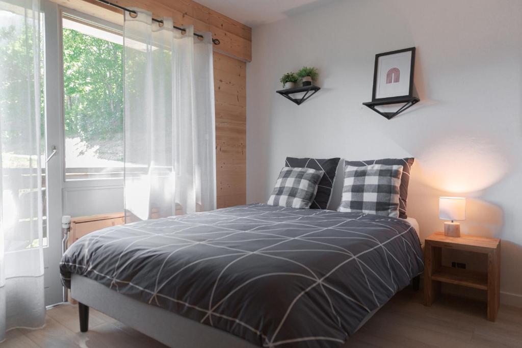 sypialnia z łóżkiem i oknem w obiekcie Alt 985M - Appartement de Charme au Grand-Bornand w mieście Le Grand-Bornand