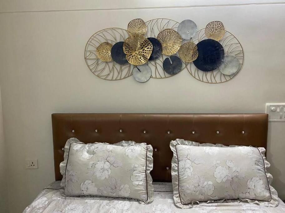 a bed with a head board with plates on the wall at Shivalaya cottage,Home away from home,mehragaon,bhimtal in Bhowāli