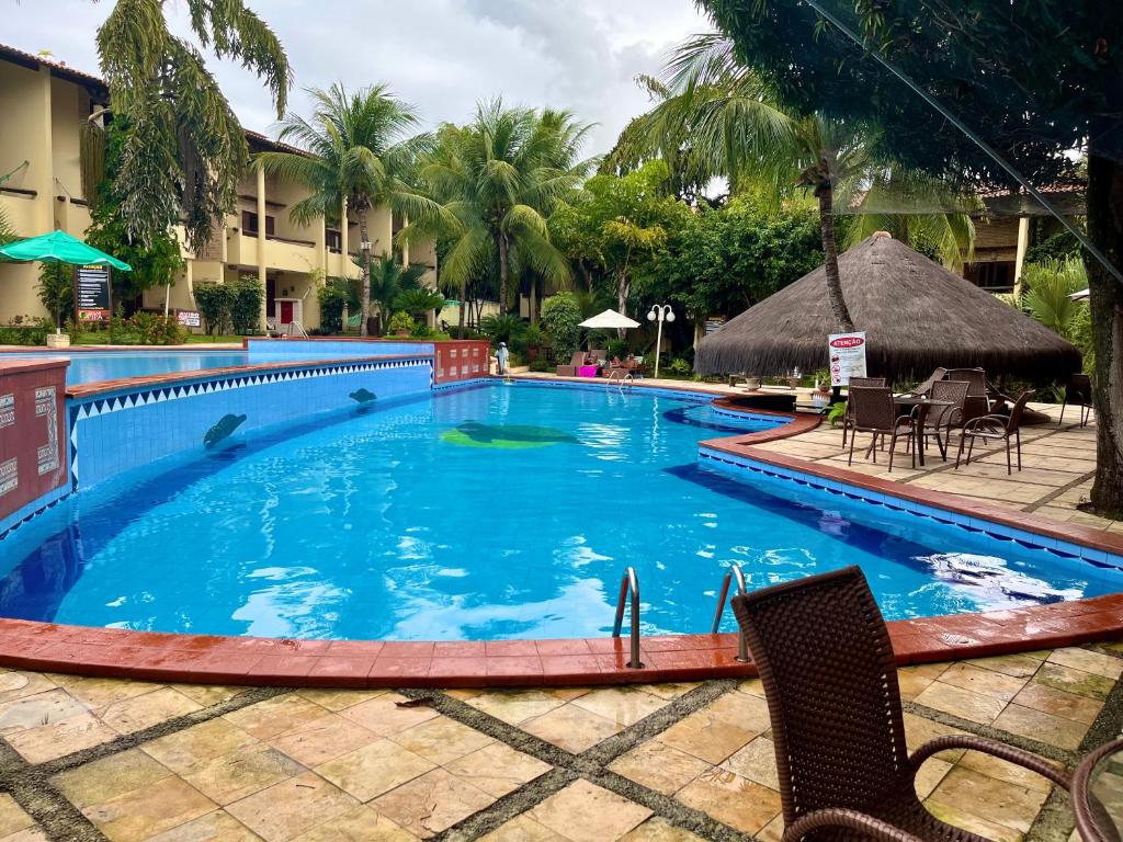 ein Swimmingpool in einem Resort mit Stühlen und Tischen in der Unterkunft Apartamentos no Solar Pipa in Pipa