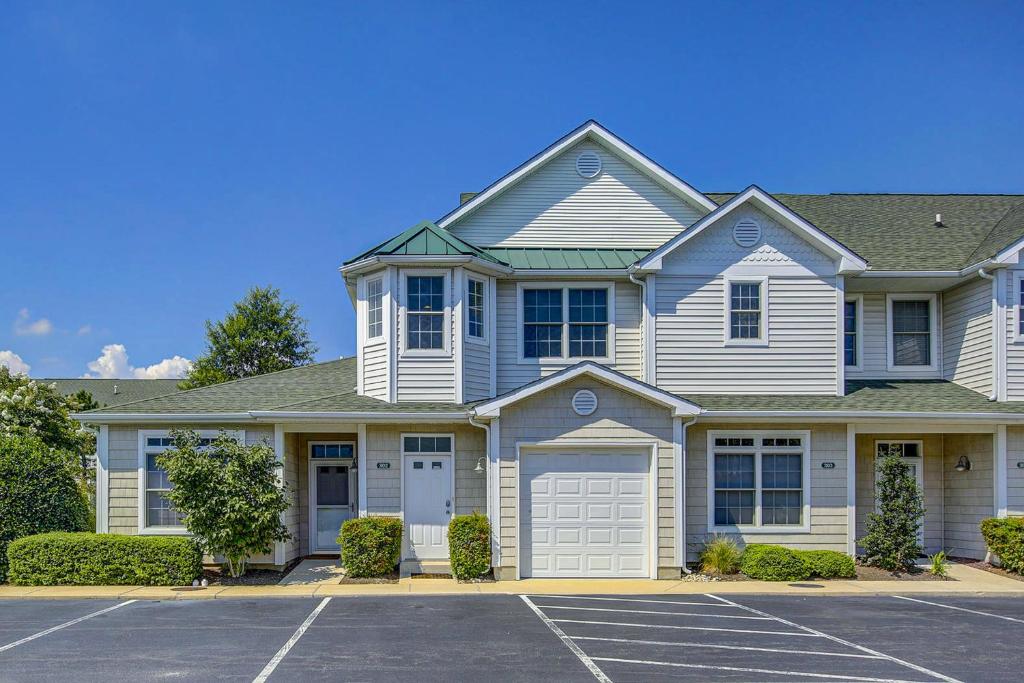 a large white house with a parking lot at The Tides -- 19973 Sandy Bottom #302 in Rehoboth Beach