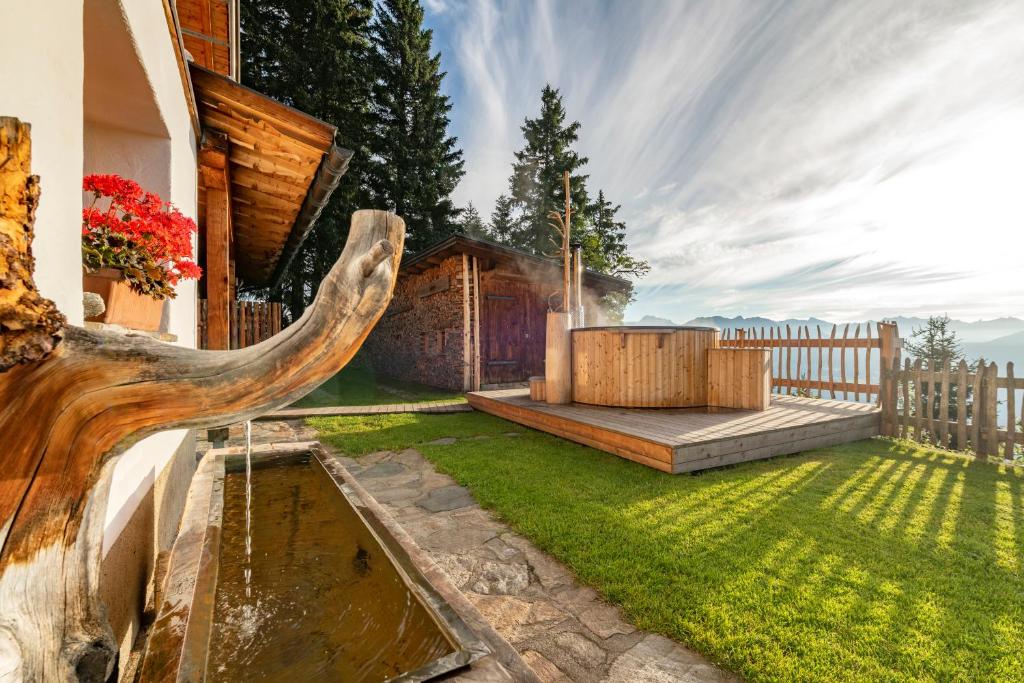 a backyard with a wooden fence and a water fountain at Golmerhaus in Schruns