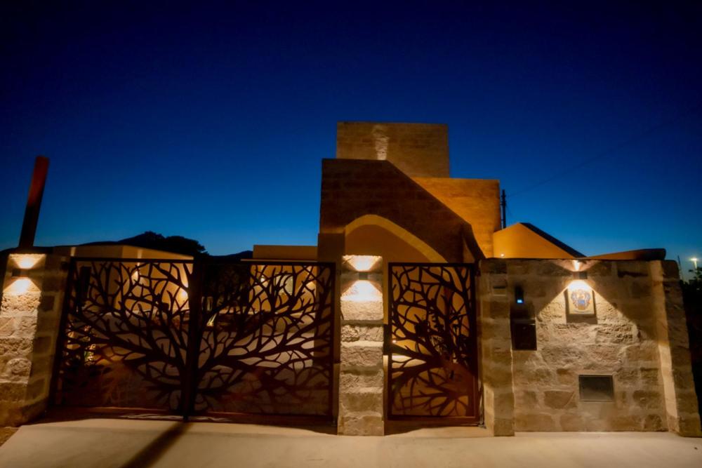 a brick building with lights on it at night at Setteminne Resort Design in Favignana