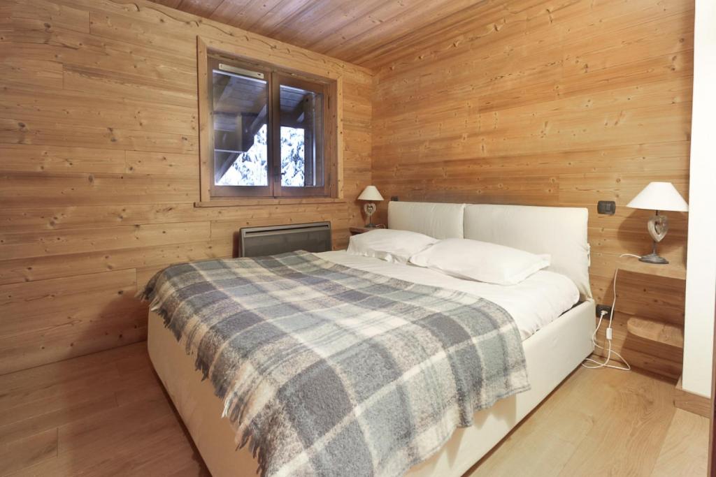 una camera da letto con un letto in una cabina di legno di House Berenice - Chamonix les Praz a Chamonix-Mont-Blanc