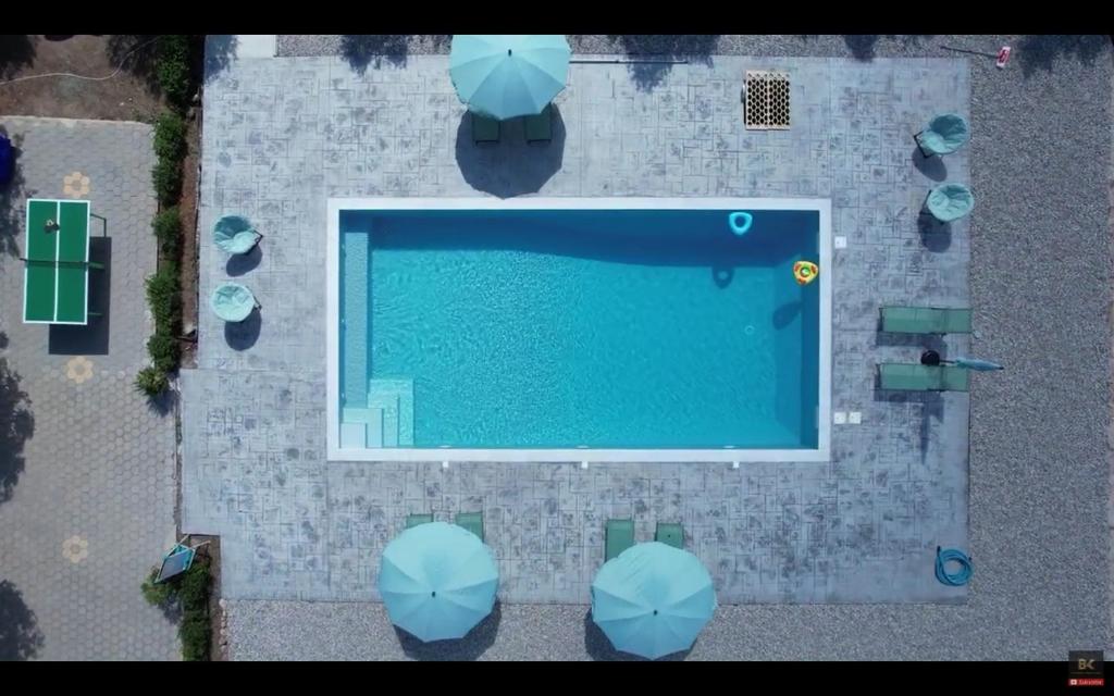 una vista aérea de una piscina con sombrillas azules en Ktima Klimentini, en Vivari