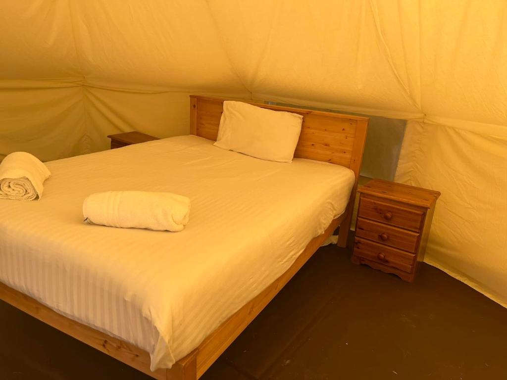 a bed in a tent with two towels on it at Tipi - Pengarreg in Aberystwyth