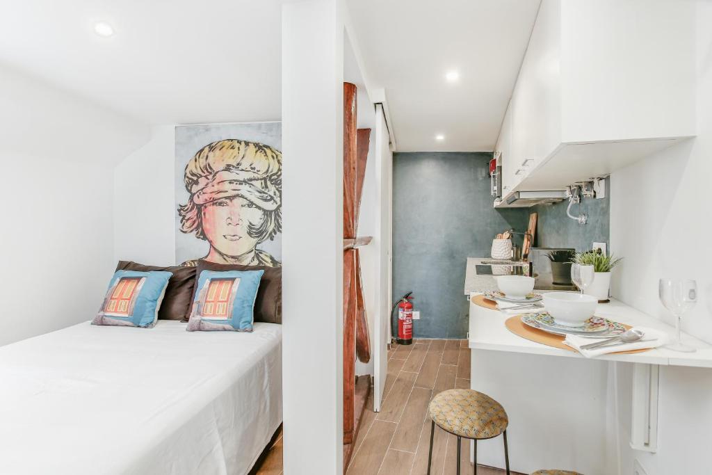 a small bedroom with a bed and a kitchen at Alfama Lyfe in Lisbon