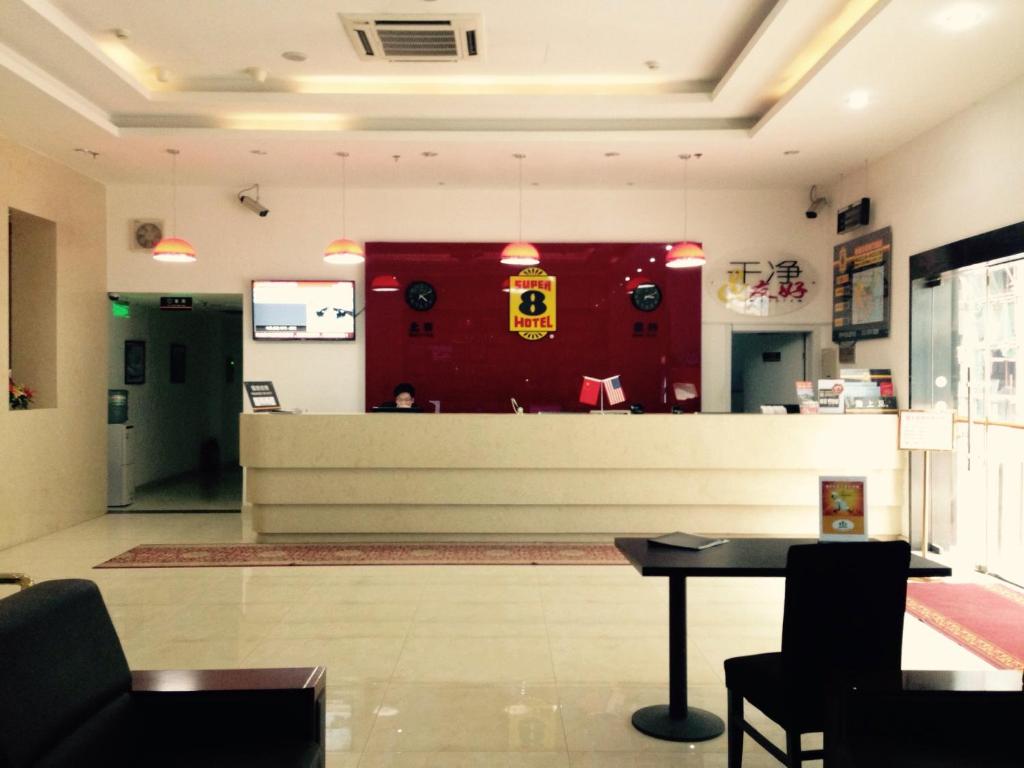 a waiting room with a counter and a red wall at Super 8 Beijing Chaoyang Road Xinglong in Beijing