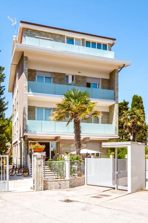 a building with a palm tree in front of it at Hotel Villa del Mare in Senigallia