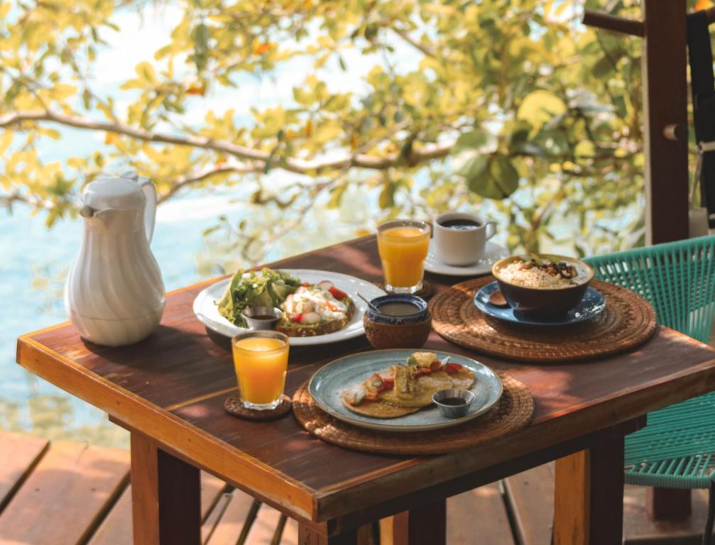 a table topped with plates of food and drinks at Khaban Bacalar Hotel Boutique in Bacalar
