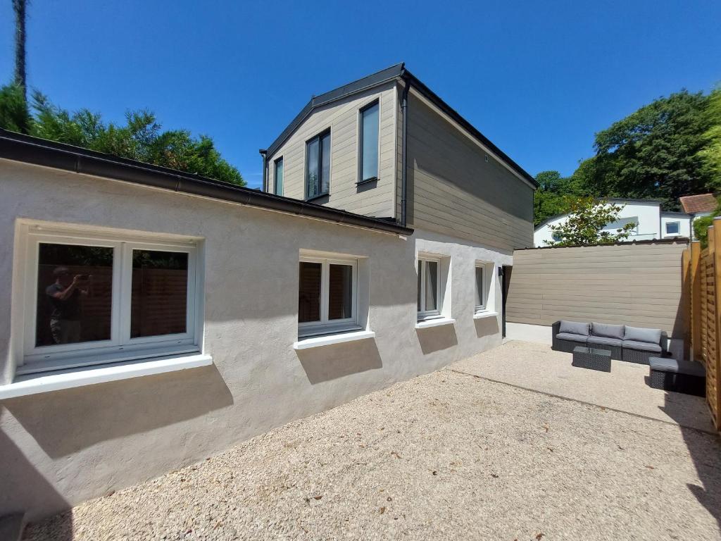 Una casa con dos ventanas en el lateral. en La Volcane - Maison au calme des Bois Royaux, en Le Chesnay