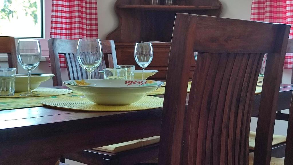 a wooden table with a bowl and wine glasses on it at Ferienhaus Rudolf in Achberg