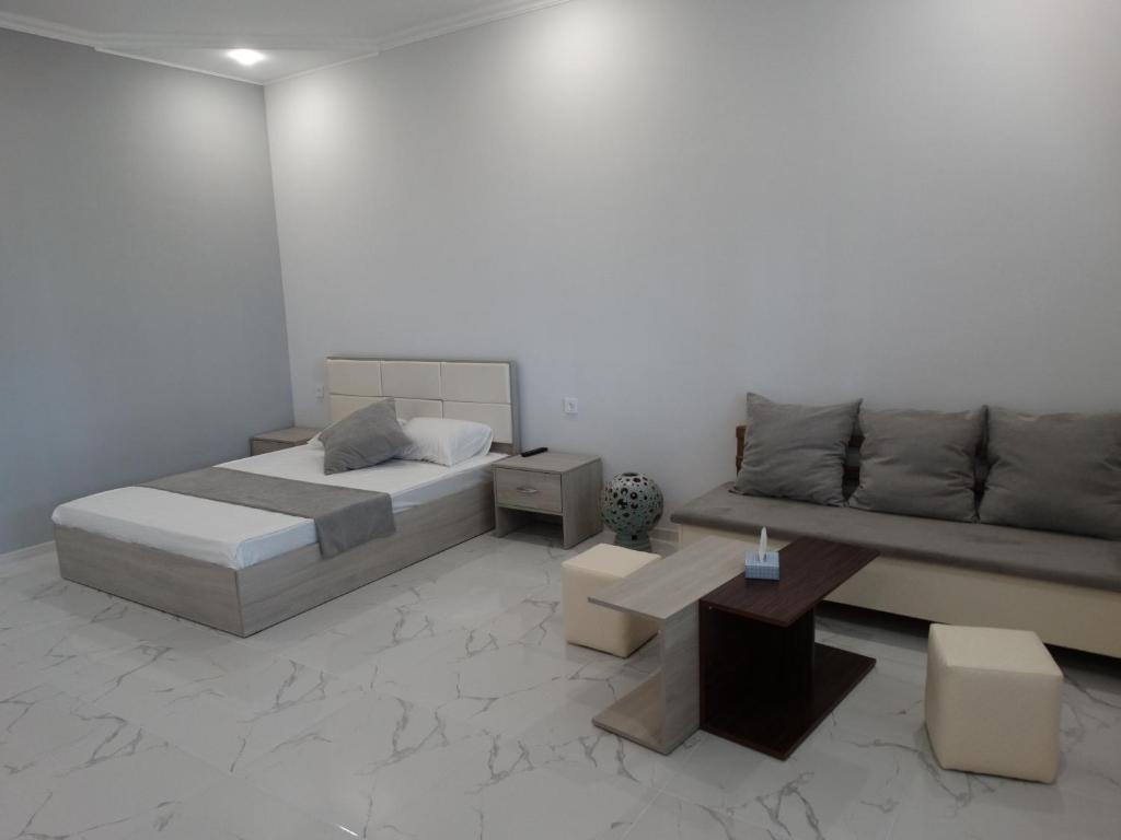 a bedroom with a bed and a couch and a table at Village Jazz in Chimankend
