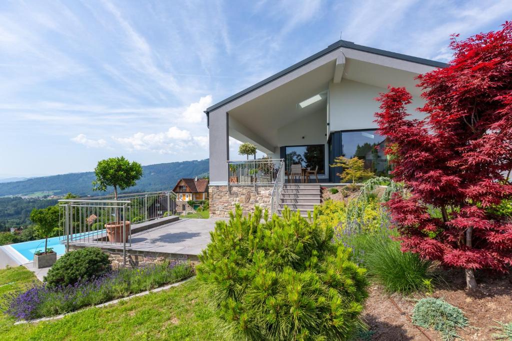 ein Haus auf einem Hügel mit Garten in der Unterkunft Greim15 --- ganzes Ferienhaus mit Fernsicht, Pool, Wellness in Deutschlandsberg