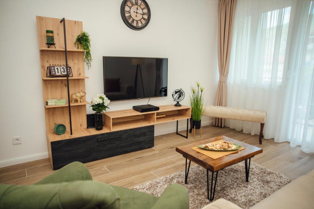 ein Wohnzimmer mit einem TV und einem Couchtisch in der Unterkunft Baia di Cattaro in Kotor