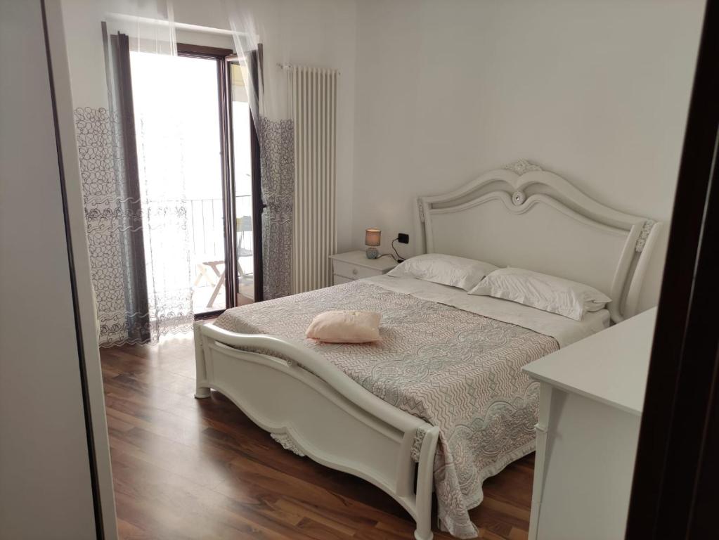 una camera da letto con un letto bianco e un cuscino rosa di Uria Rooms & Suite B&B a Vieste