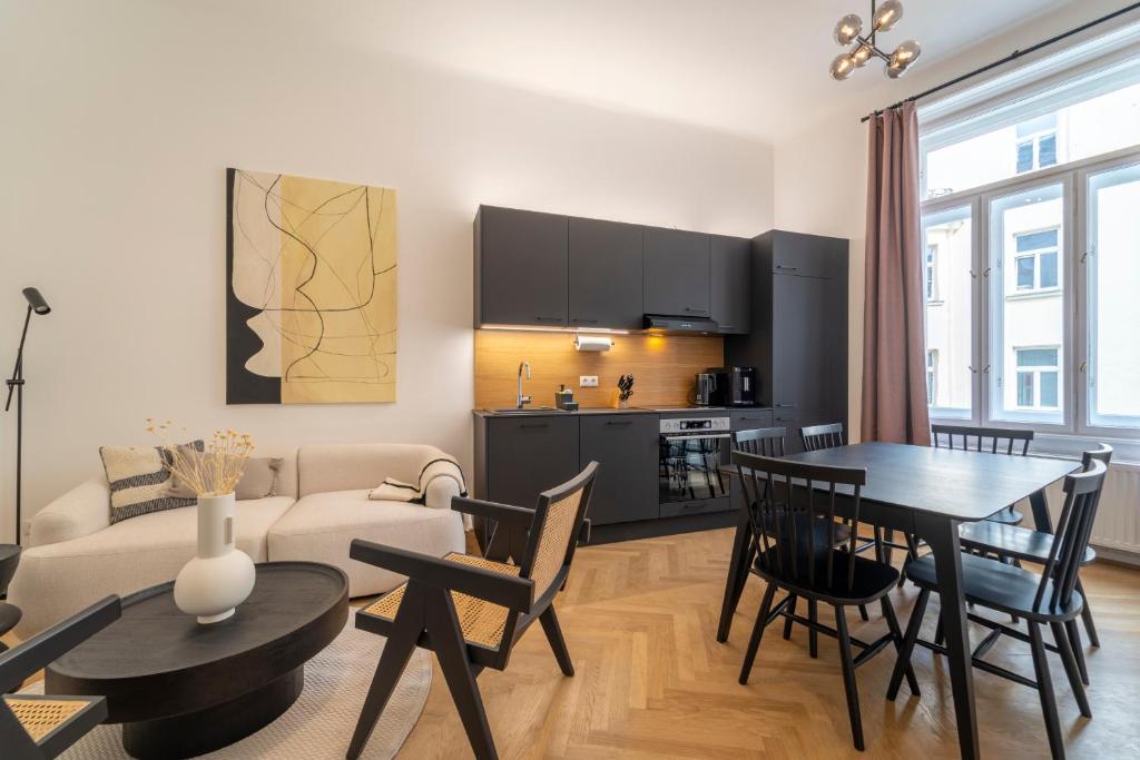 kuchnia i salon ze stołem i krzesłami w obiekcie josef's home I Deluxe Apartment in Ideal Location w Wiedniu