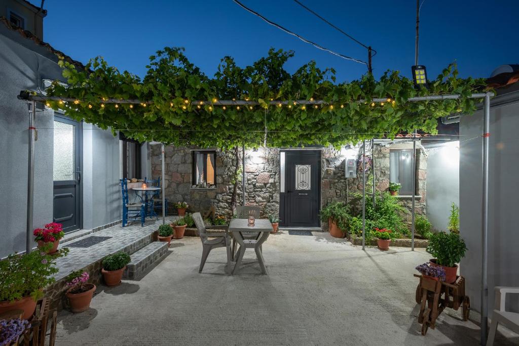 patio ze stołem, krzesłami i roślinami w obiekcie Ρίζες - Rizes w mieście Repanídhion