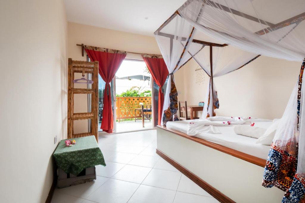 1 dormitorio con cama, escalera y ventana en RaCoCo Villa, en Jambiani