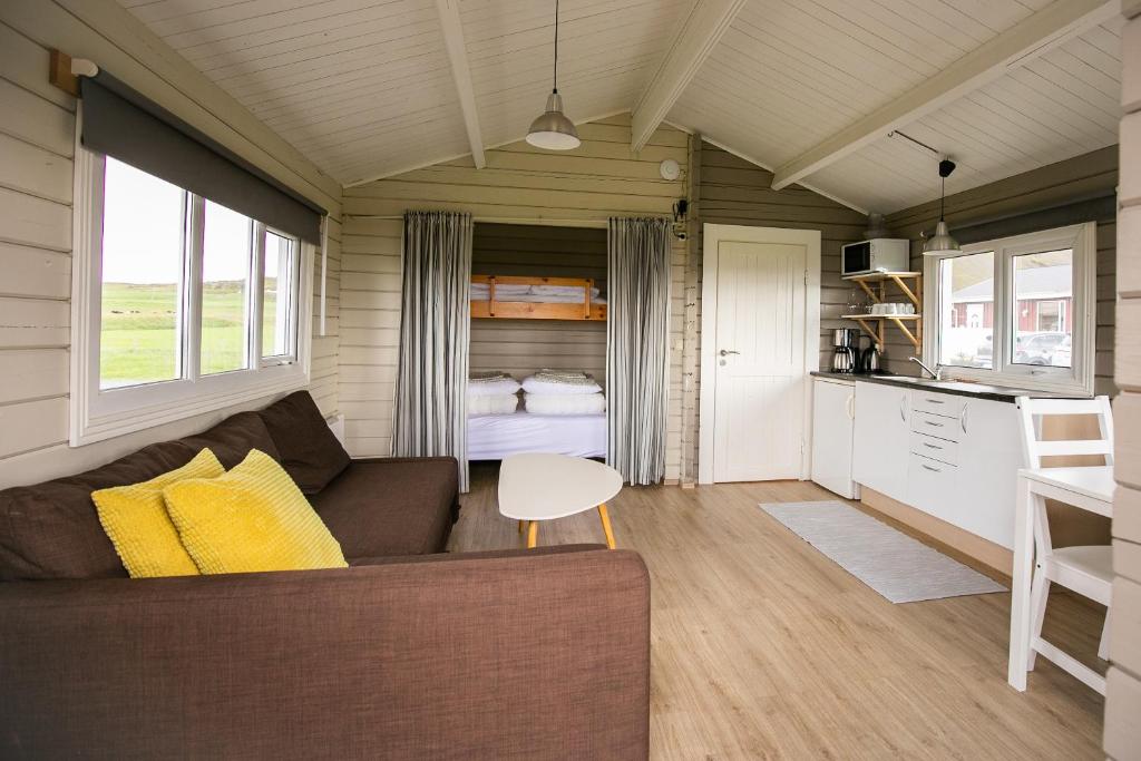 una sala de estar y cocina en una casa pequeña en Móar Cottage, en Akranes