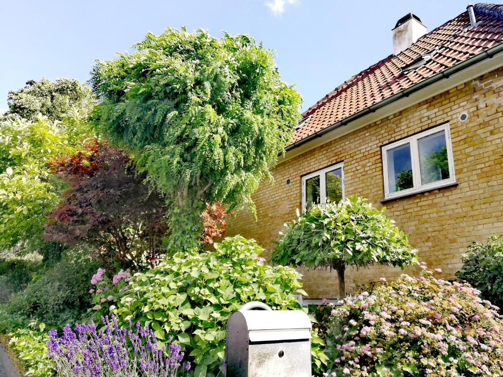 una casa con un giardino di fiori di fronte di Room in a Danish cottage with garden view, 10 min to CPH a Gentofte