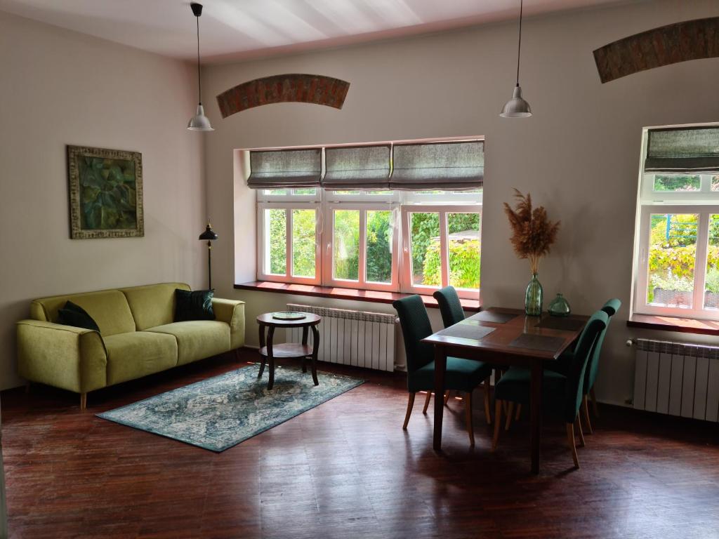 - un salon avec un canapé, une table et des chaises dans l'établissement Apartament w Starej Szkole, à Srebrna Góra