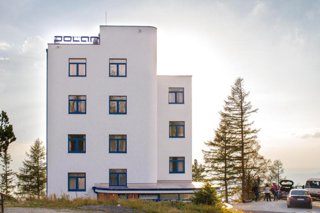 un edificio blanco alto con un letrero. en Vila Polar, en Štrbské Pleso