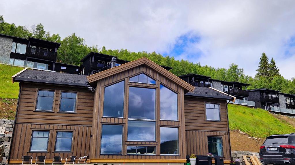 a house with a reflection of the sky in the windows at Mlodge - The Mountain Lodge in Sogndal