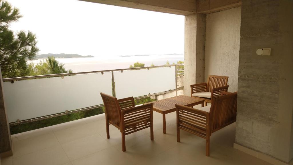a balcony with a table and chairs and a view of the ocean at Vila Marija-Roza in Drage