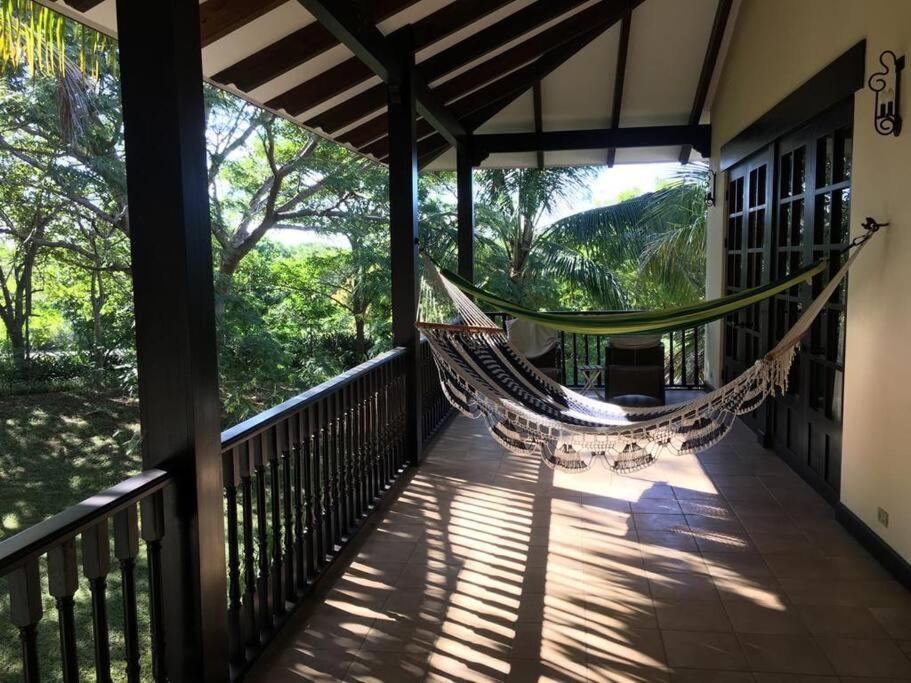 a hammock on the porch of a house at 3 Bedroom Villa in Hacienda Pinilla in Tamarindo