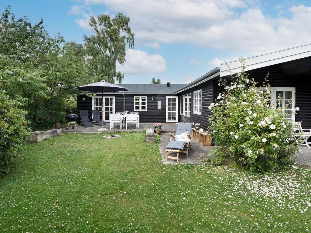 una casa negra con un patio con un patio en Holiday home Helsinge, en Helsinge