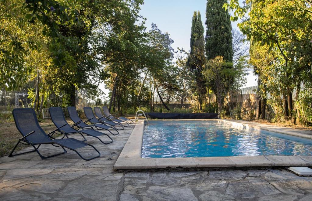 a row of chairs sitting next to a swimming pool at Domaine Saint Laurent in Béziers