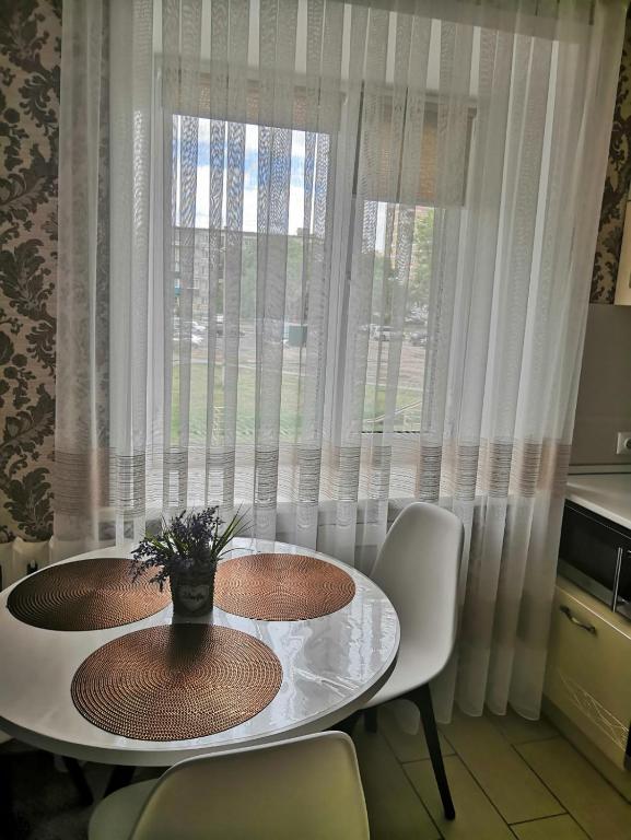 a table and chairs in front of a window at Аренда квартиры город Рудный in Rudny