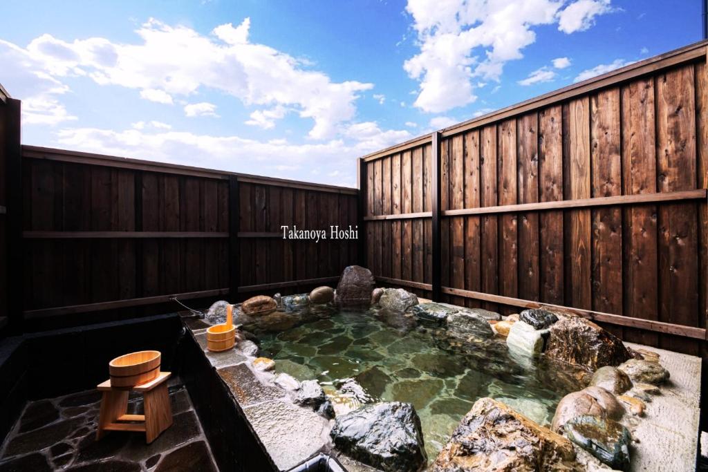 a hot tub in a backyard with a fence at Takanoya Hoshi - Vacation STAY 91923 in Yufuin