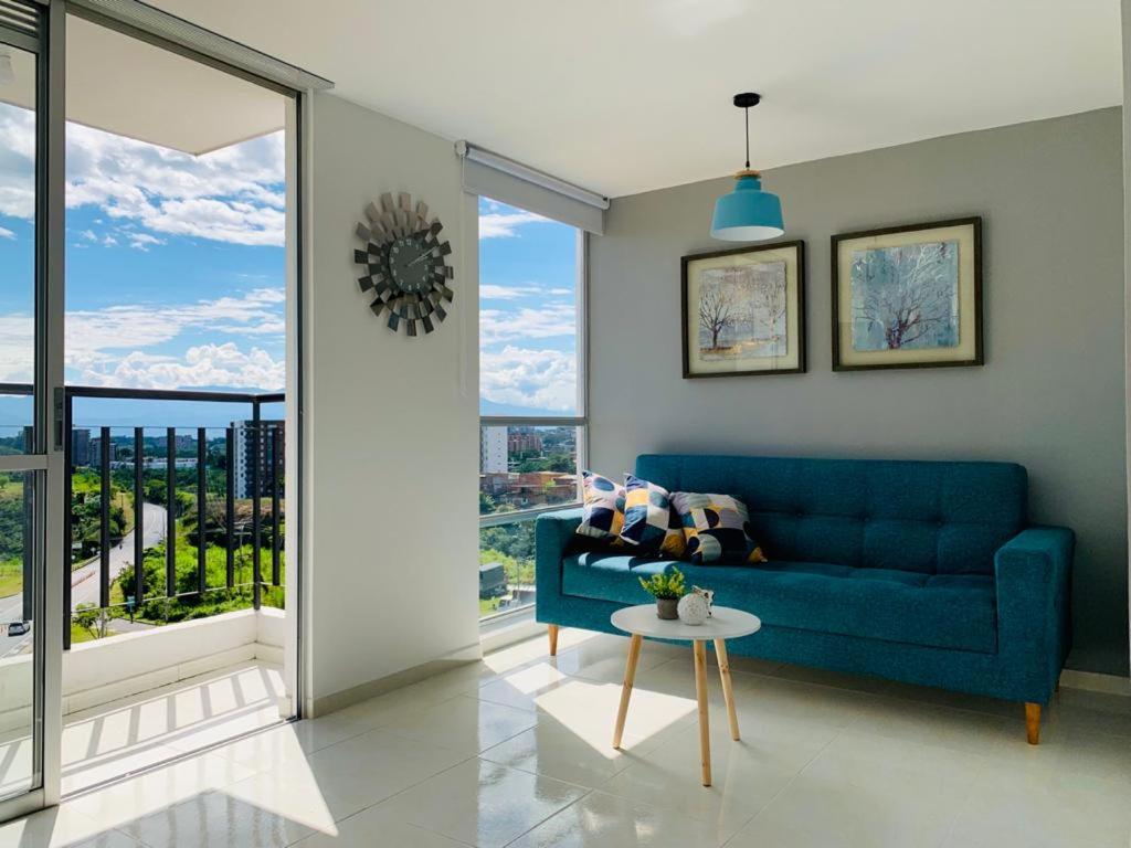a living room with a blue couch and a table at Espectacular apartamento completo en Pereira in Pereira