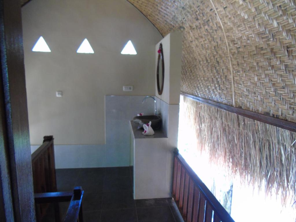 Habitación con escalera y pared con ventana. en Villas Ganjor, en Gili Meno