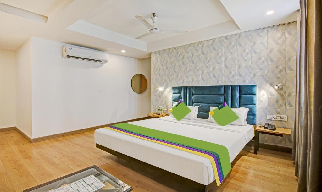 a bedroom with a large bed and a table at Treebo Trend Ahinsa Residency Sohna Road in Gurgaon