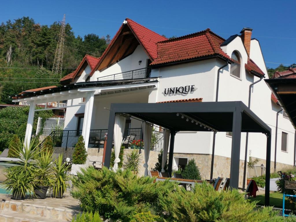 um edifício branco com um telhado vermelho em Villa Unique em Eşelniţa