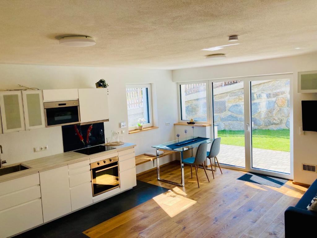 a kitchen with white cabinets and a table and a dining room at Ferienwohnung Kerschbaumer in Gries am Brenner