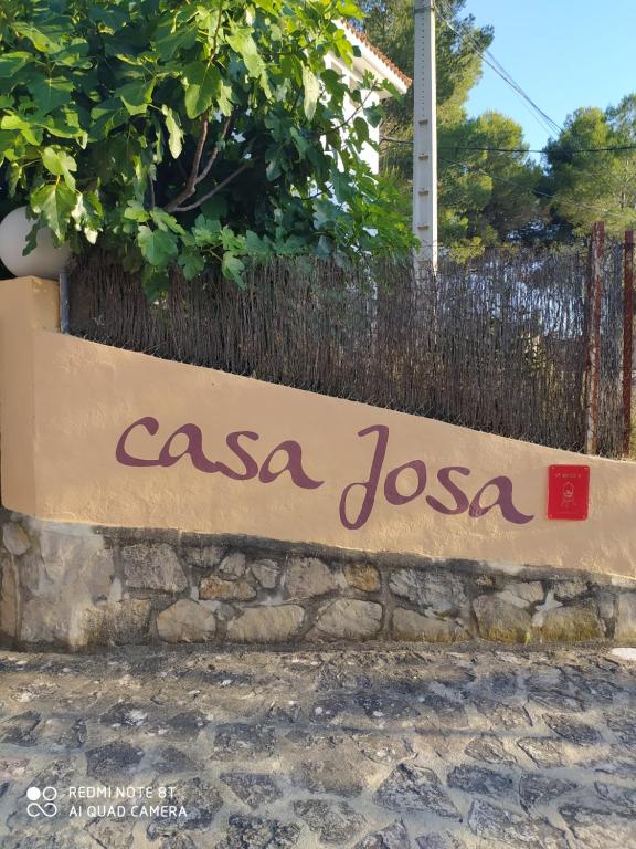 Ein Schild, auf dem steht, casa jossa an einer Steinmauer in der Unterkunft Casa Josa in Ontinyent