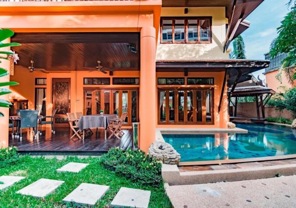a house with a swimming pool in front of it at Villano Dara pool villa in Na Jomtien