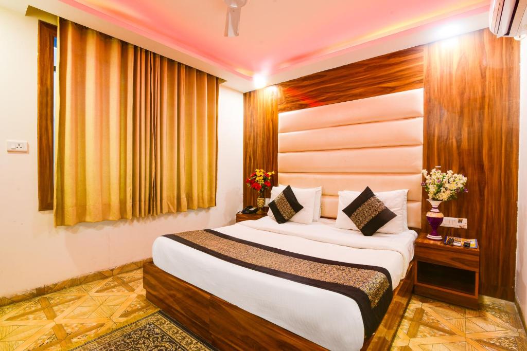 a bedroom with a large bed in a room at Hotel Olivia Inn At Delhi Airport in New Delhi