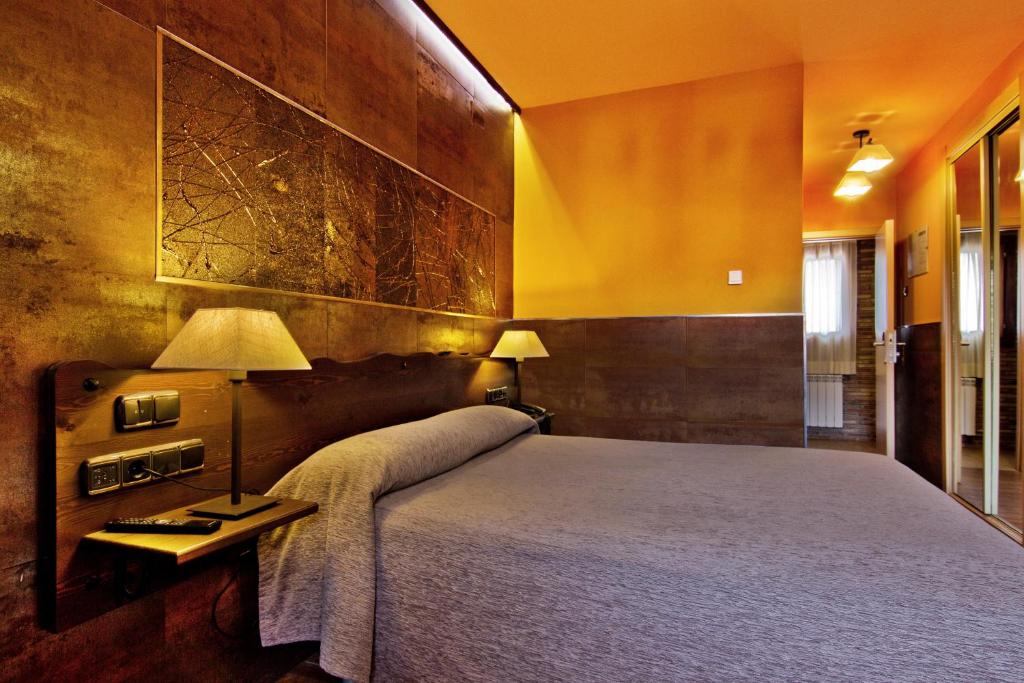 Un dormitorio con una cama grande y una mesa con una lámpara. en Hotel Doña Blanca, en Albarracín