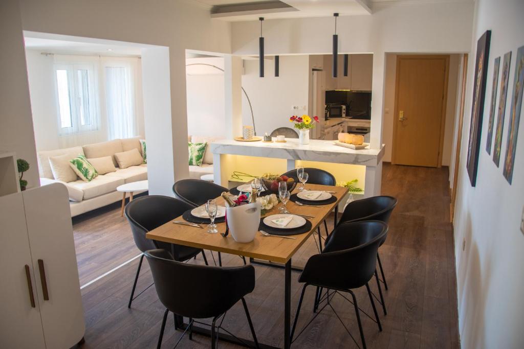 a kitchen with a table, chairs and a refrigerator at Lydia Hotel in Rhodes Town