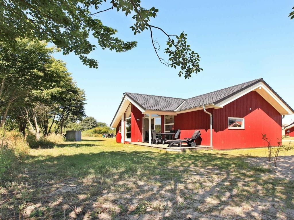 a red house with a yard at 8 person holiday home in Gro enbrode in Großenbrode