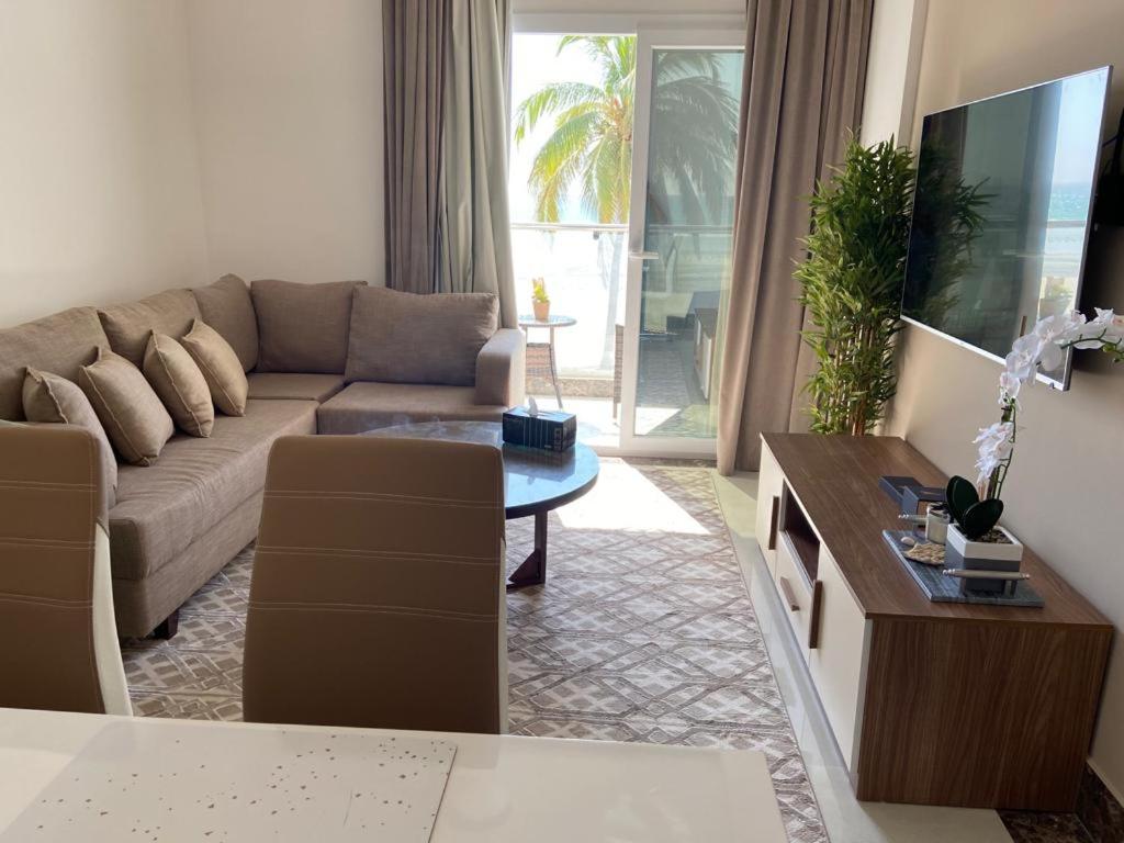 a living room with a couch and a table at Lovely Beach Apartment in Salalah