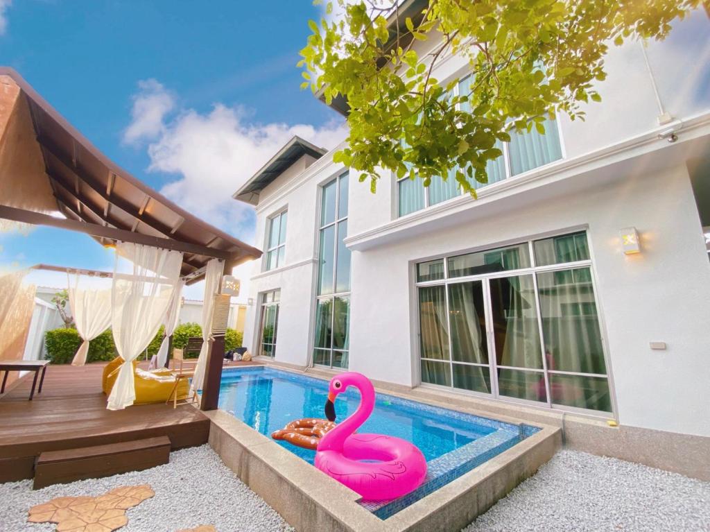 a swimming pool with a pink flamingo in front of a house at Malibu Pool Villa Pattaya in Pattaya Central