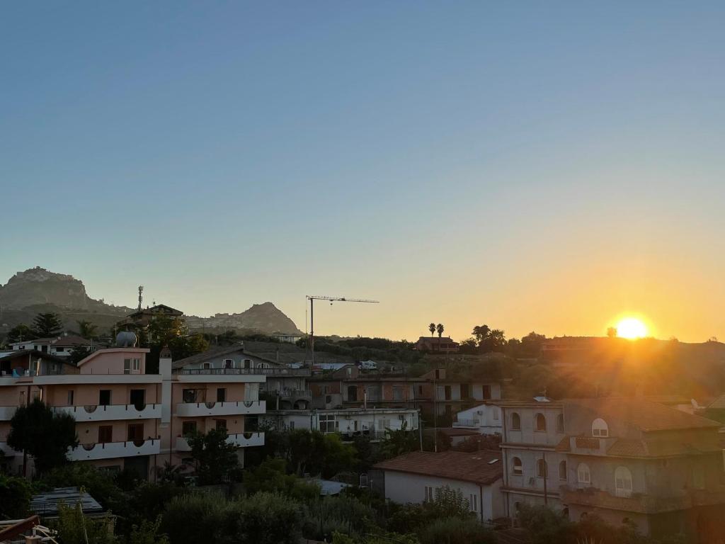 un coucher de soleil sur une ville avec des bâtiments dans l'établissement Pipa’s SunTrap, à Taormine