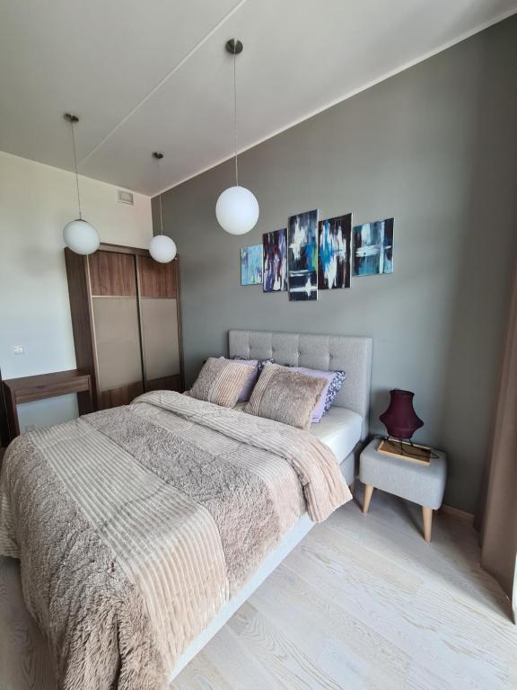 1 dormitorio con 1 cama grande y 2 luces colgantes en The Familytree- Martensi, en Pärnu