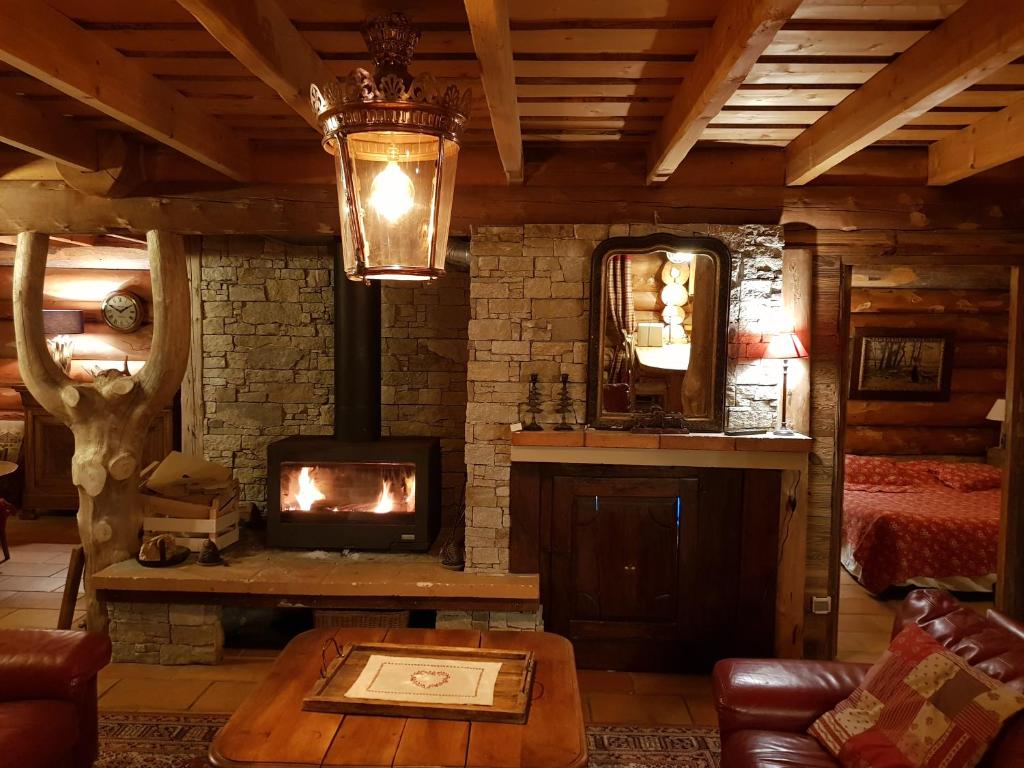 a living room with a fireplace in a log cabin at Magnifique chalet en rondins avec sauna - Vercors in Villard-de-Lans