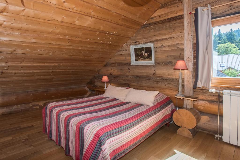 a bedroom with a bed in a log cabin at Magnifique chalet en rondins avec sauna - Vercors in Villard-de-Lans